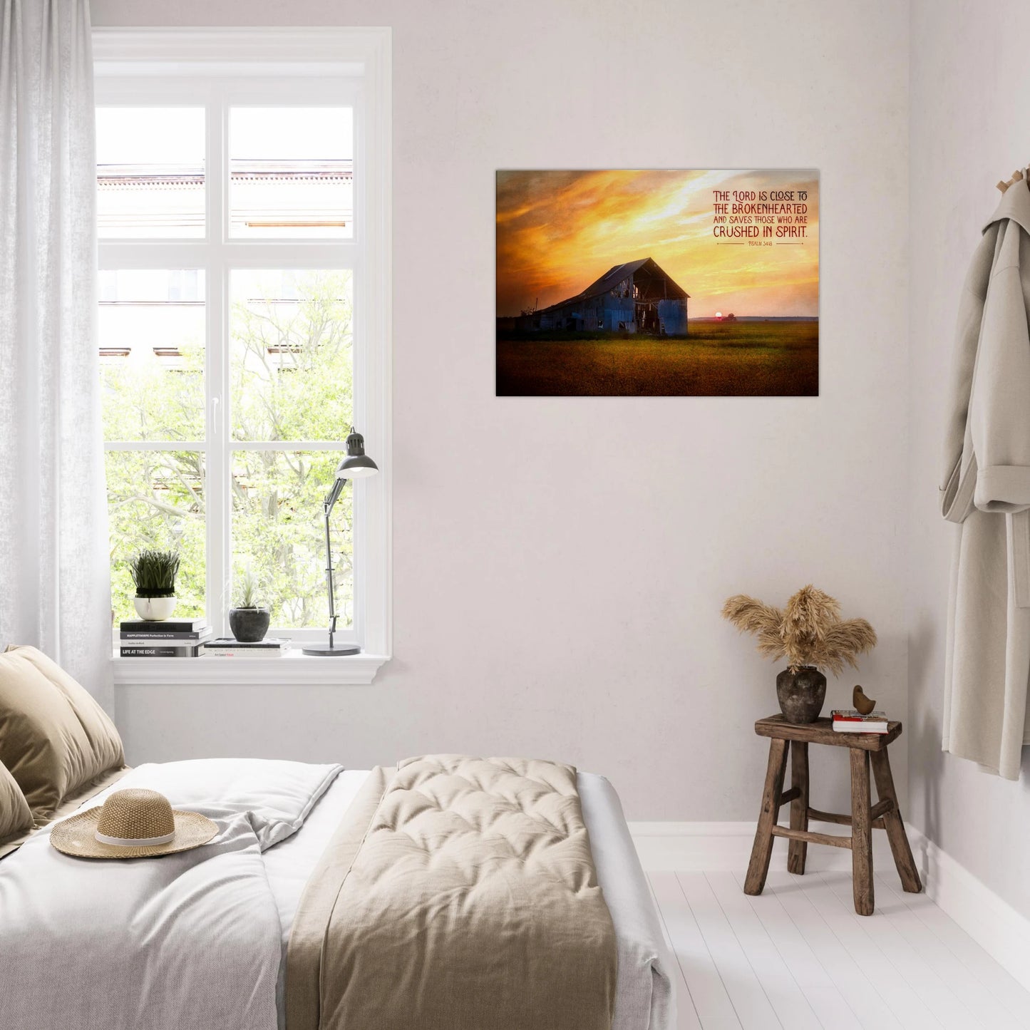 Room interior with a bed, window, and wall art of a sunset over a mountain.