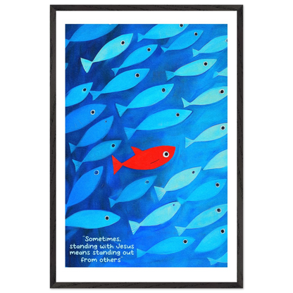 Framed wall art featuring a school of blue fish with a single red fish, and text that reads: 'Sometimes standing with Jesus means standing out from others.'.