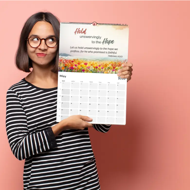Woman holding a calendar with a floral design and text on a pink background