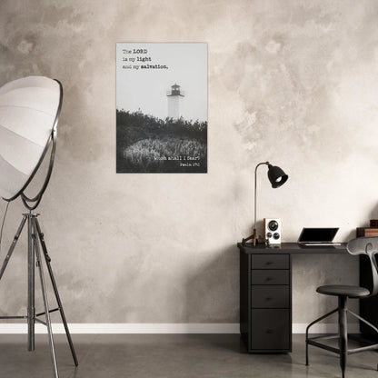 Poster with a lighthouse on a wall in a room with a desk and lamp.