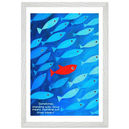 Framed wall art featuring a school of blue fish with a single red fish, and text that reads: 'Sometimes standing with Jesus means standing out from others.'.