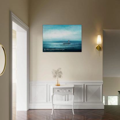 A wall art print featuring a lighthouse with a backdrop of the sea and sky, including a quote about perfect peace displayed in a cozy minimalist hall  with plant decor