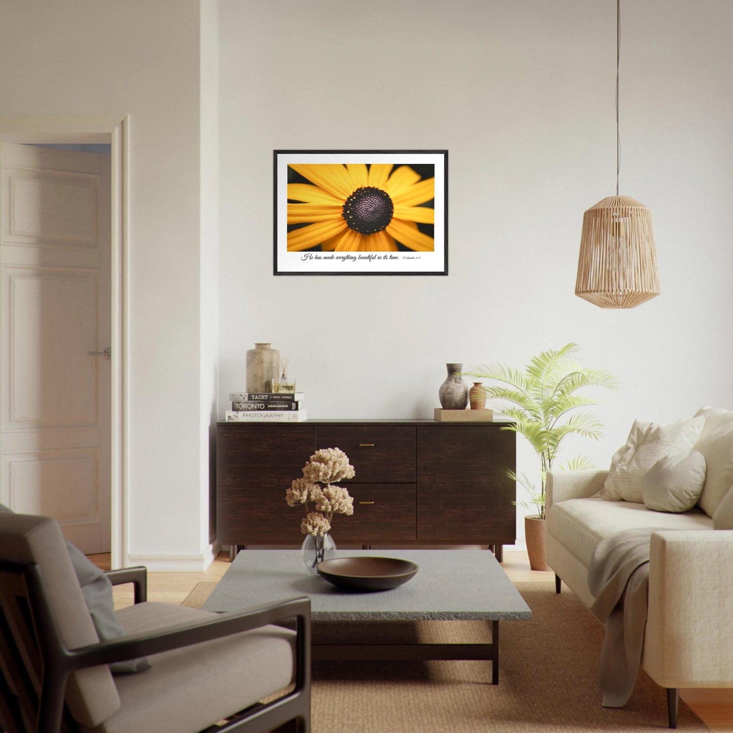 A framed art print of a close-up yellow flower with a quote from Ecclesiastes 3:11, 'He has made everything beautiful in its time.' displayed in a warm beige tone minimalist living room