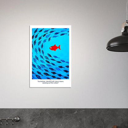 Christian wall art showing a red fish swimming against a school of blue fish with the message Sometimes standing with Jesus means standing out displayed in a modern minimalist room