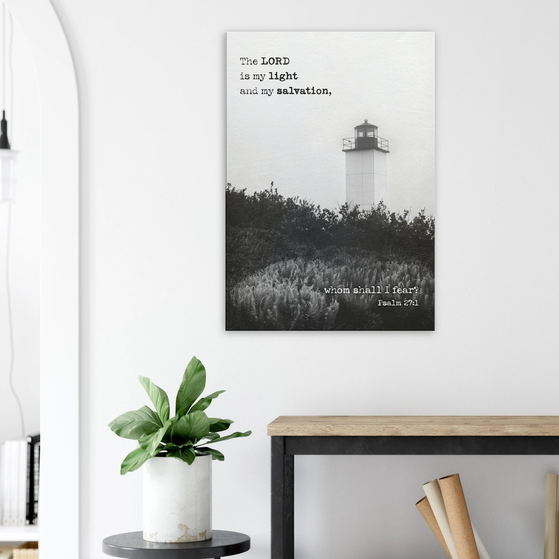 Black-and-white lighthouse Christian wall art with Psalm 27:1 hanging above a minimalist console table and plant.