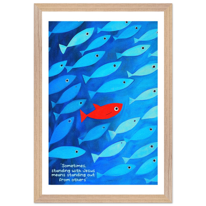 Framed wall art featuring a school of blue fish with a single red fish, and text that reads: 'Sometimes standing with Jesus means standing out from others.'.