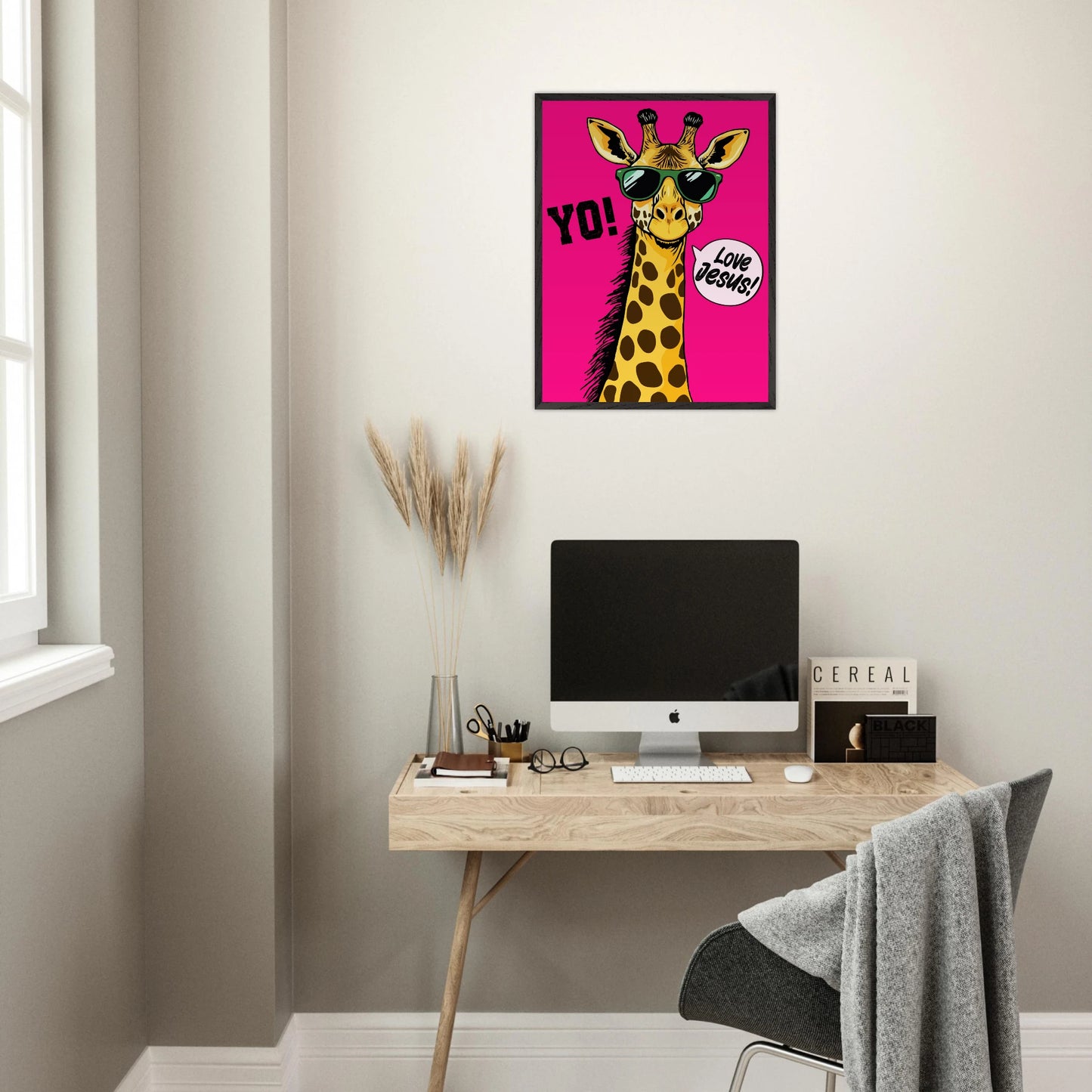 Playful Christian wall art featuring a giraffe wearing sunglasses on a bright pink background with Yo and Love Jesus displayed above a modern home office desk setup