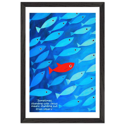 Framed wall art featuring a school of blue fish with a single red fish, and text that reads: 'Sometimes standing with Jesus means standing out from others.'.