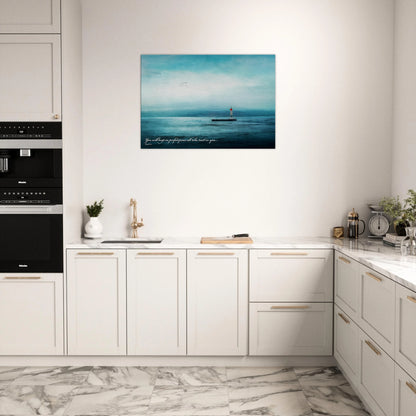 A wall art print featuring a lighthouse with a backdrop of the sea and sky, including a quote about perfect peace displayed in a bright minimalist kitchen 