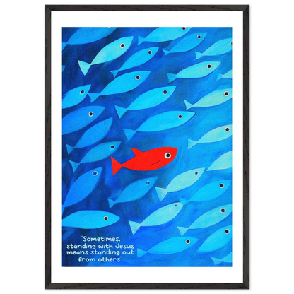 Framed wall art featuring a school of blue fish with a single red fish, and text that reads: 'Sometimes standing with Jesus means standing out from others.'.
