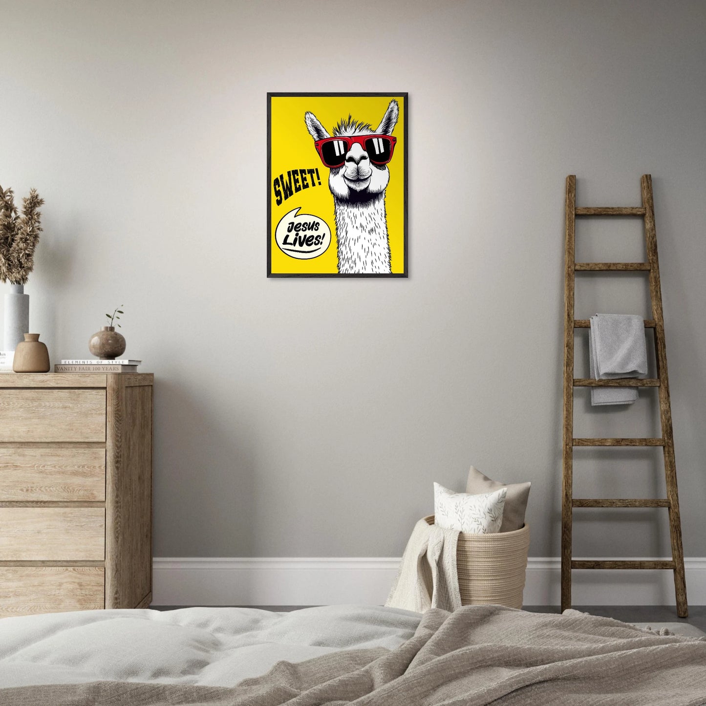 Framed Christian wall art featuring a white llama wearing red sunglasses on a bright yellow background with playful text reading SWEET and Jesus Lives, displayed above a bed in a calm minimalist bedroom with neutral tones, wooden ladder decor, and soft textiles