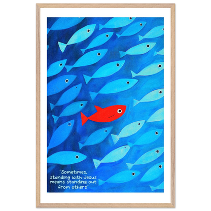 Framed wall art featuring a school of blue fish with a single red fish, and text that reads: 'Sometimes standing with Jesus means standing out from others.'.