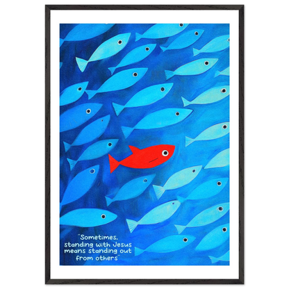 Framed wall art featuring a school of blue fish with a single red fish, and text that reads: 'Sometimes standing with Jesus means standing out from others.'.