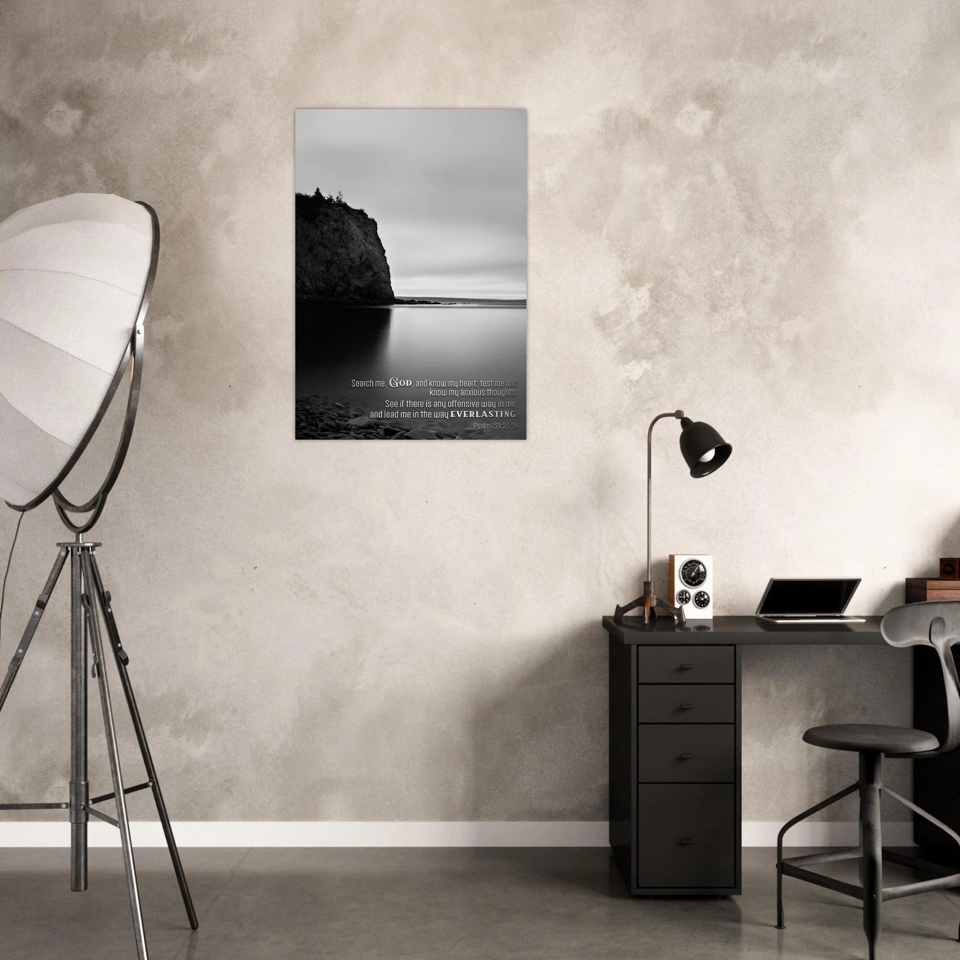Modern office space with a desk, lamp, and wall art featuring a landscape.