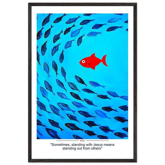 Framed Christian wall art featuring a red fish swimming in water with blue fish, and the text 'Sometimes standing with Jesus means standing out from others' as a quote.