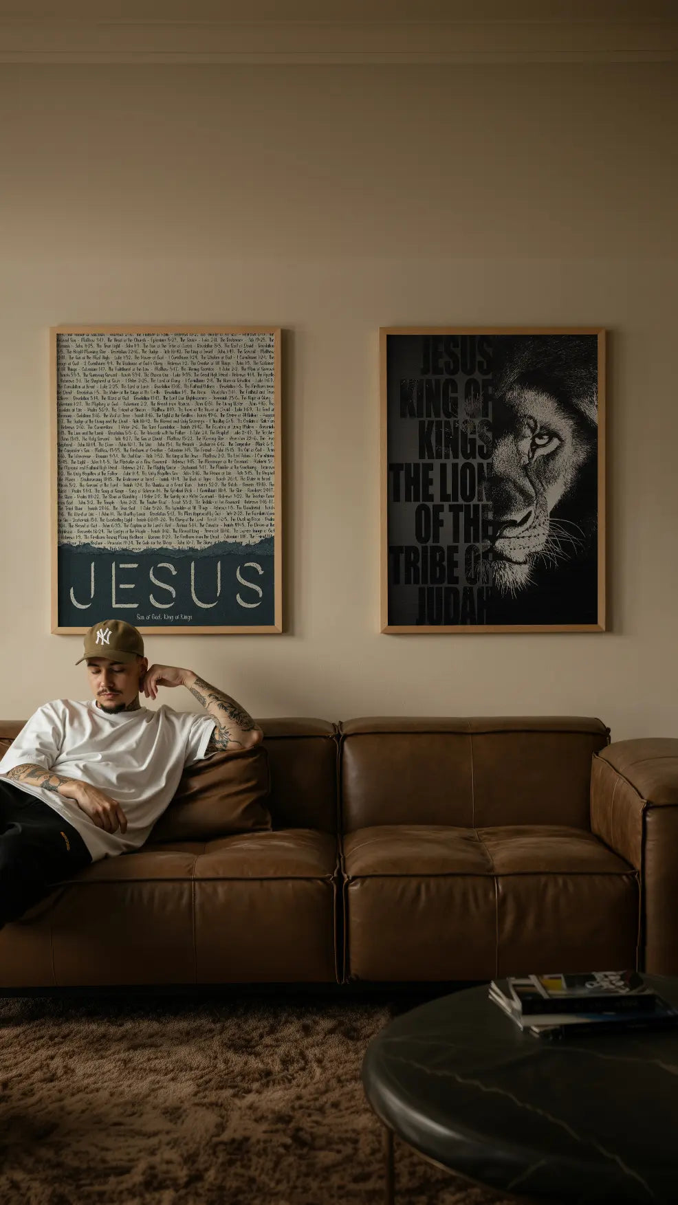 Person sitting on a brown couch with framed artwork on the wall.