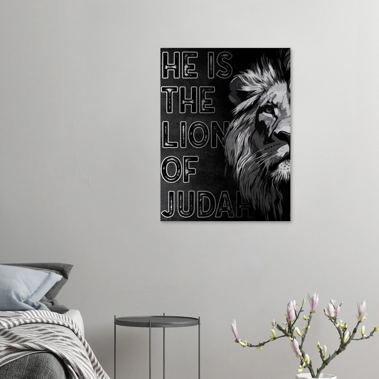 Christian Lion of Judah print hanging above a cozy bedroom corner with a gray chair, soft bedding, and a side table with flowers.