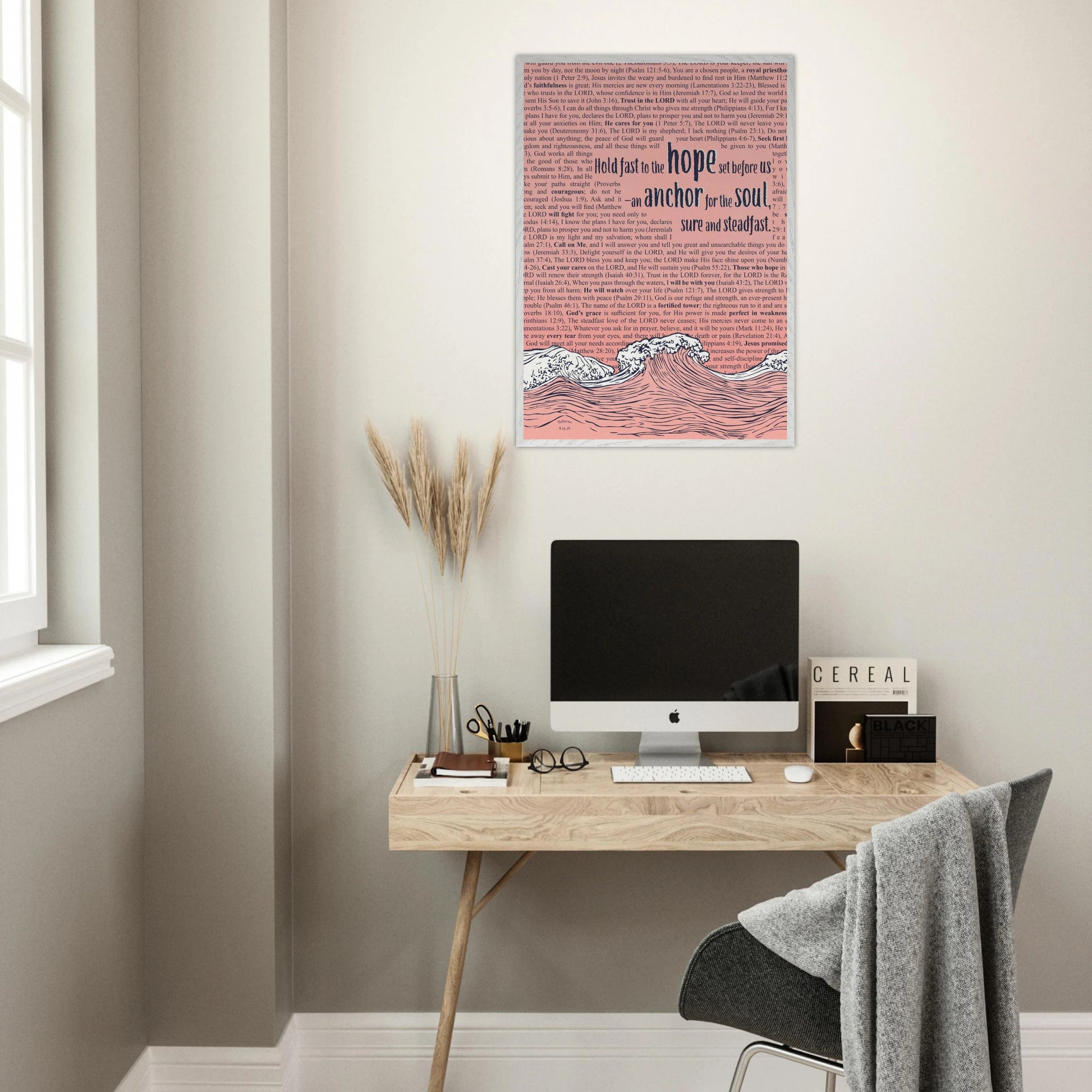 framed wave and anchor christian print in pink with bible verses hanging above a modern desk workspace