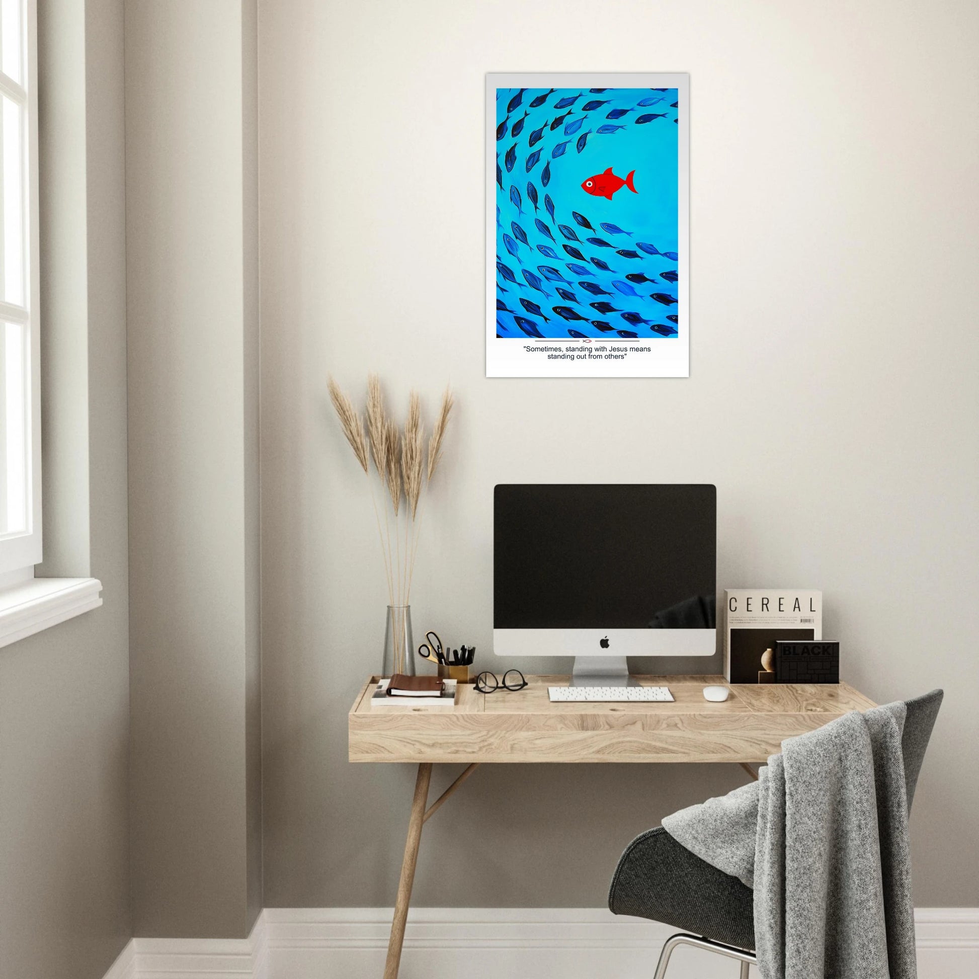 Christian wall art showing a red fish swimming against a school of blue fish with the message Sometimes standing with Jesus means standing out displayed in a minimalist office