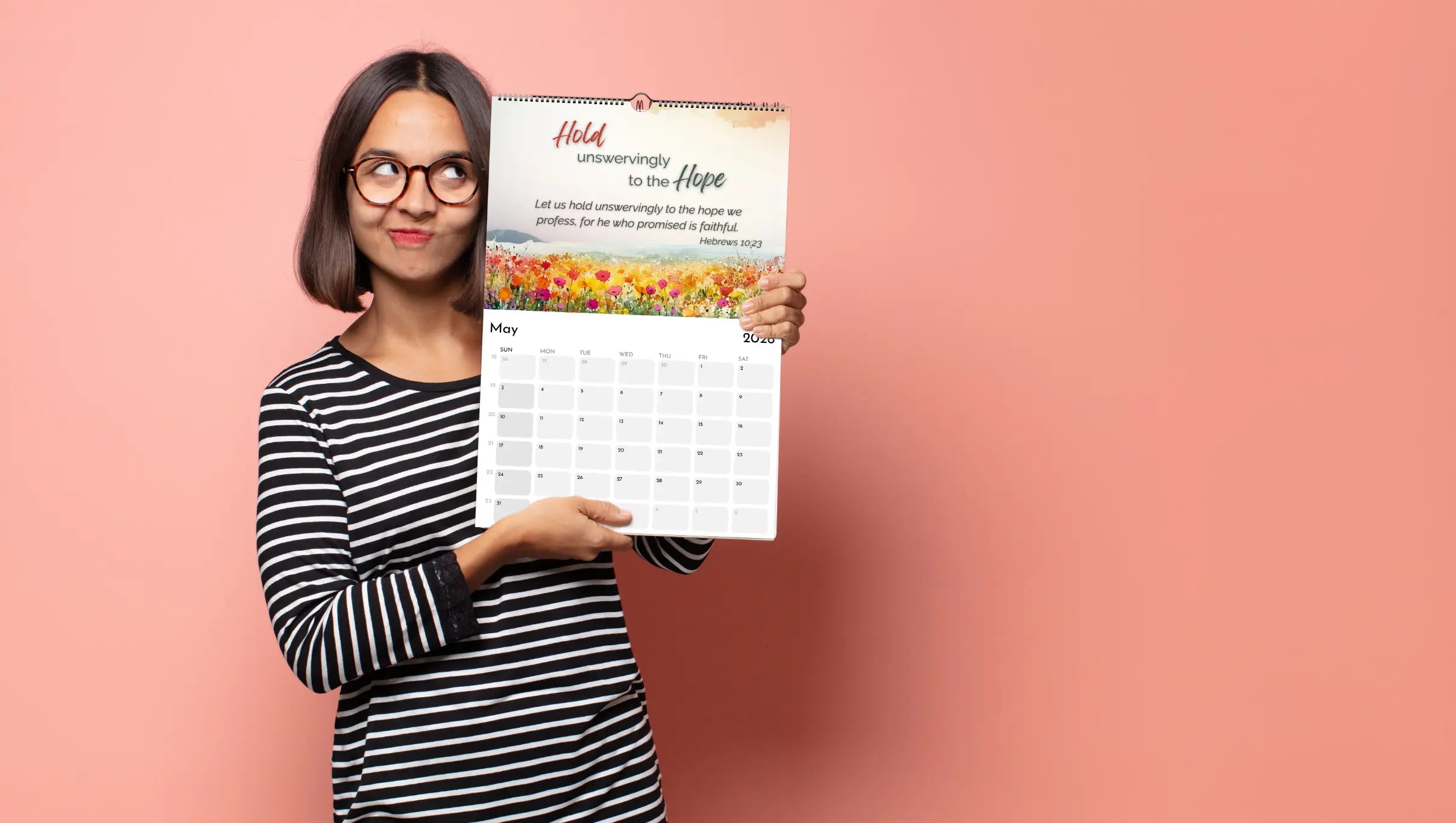 Woman holding a calendar with a motivational quote on a pink background