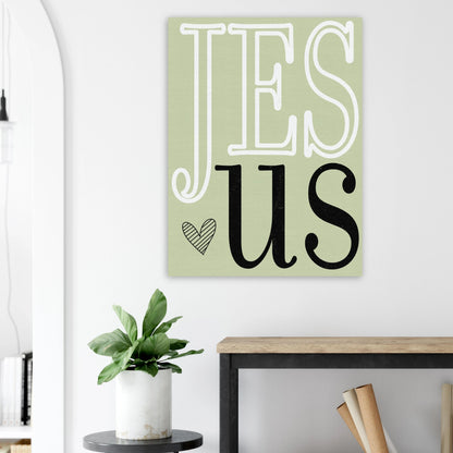 Decorative wall art with 'Jesus' on a light green background in a room setting.