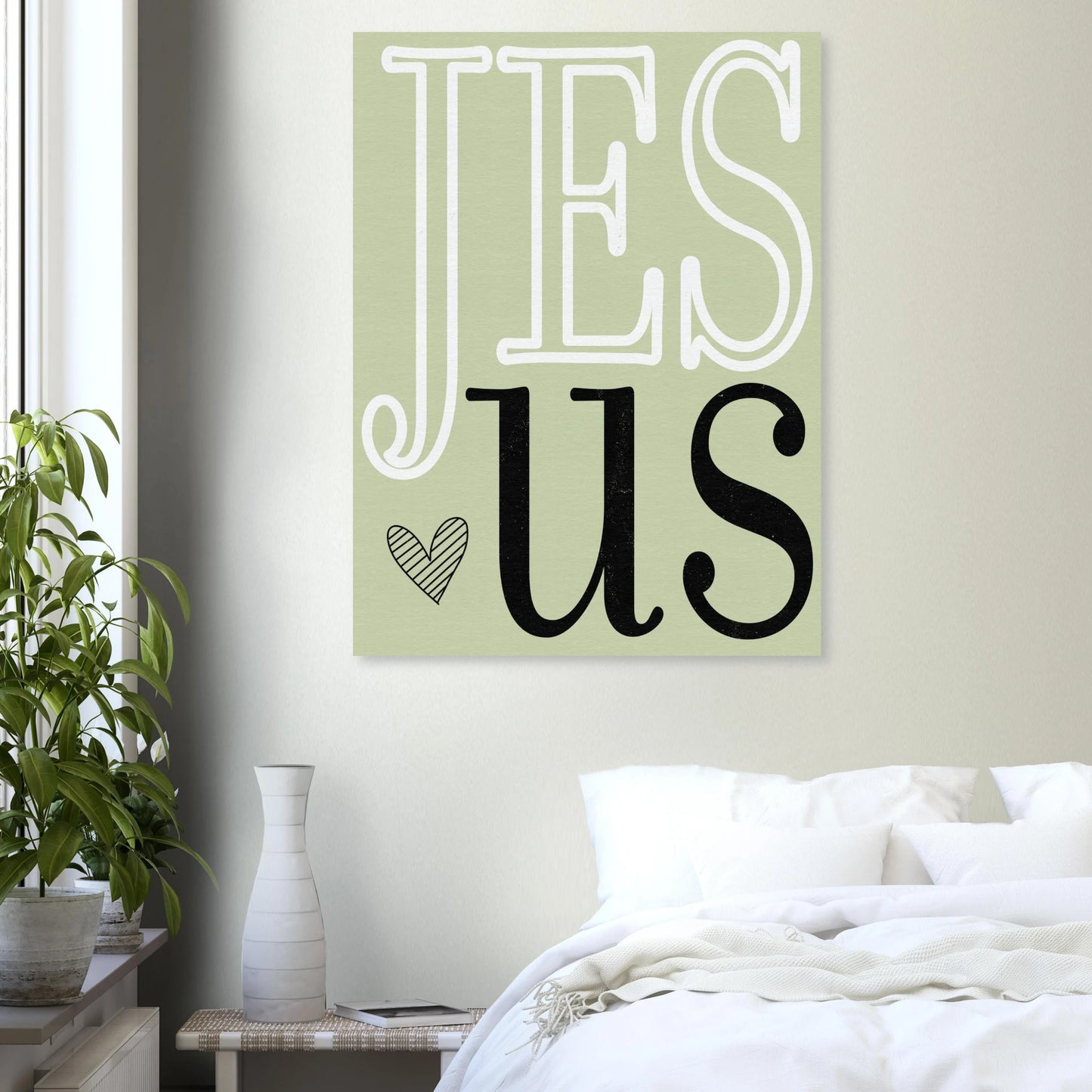 Decorative wall art with 'Jesus' on a light green background in a bedroom setting.