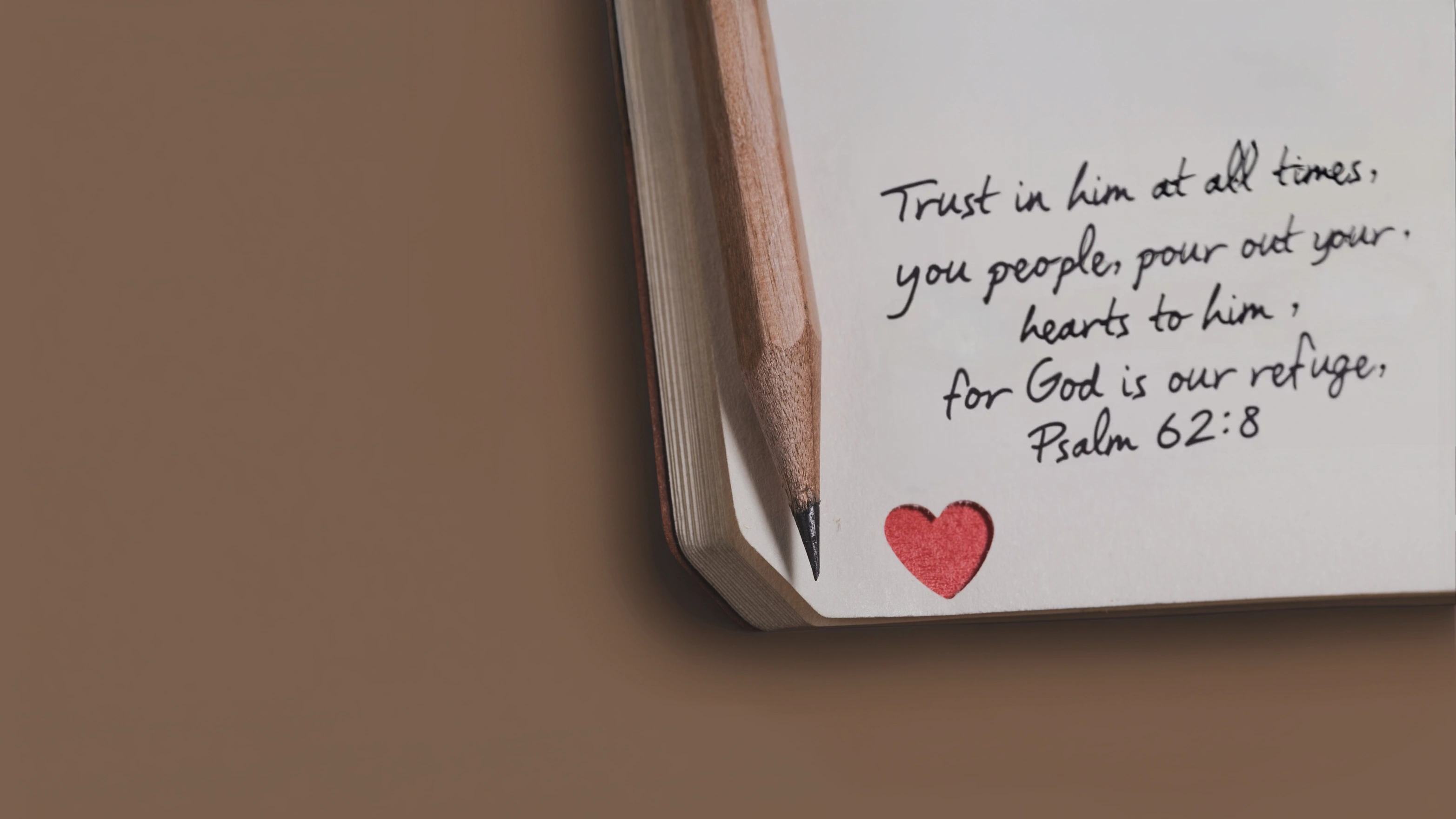 Notebook with a quote and heart symbol on a brown background