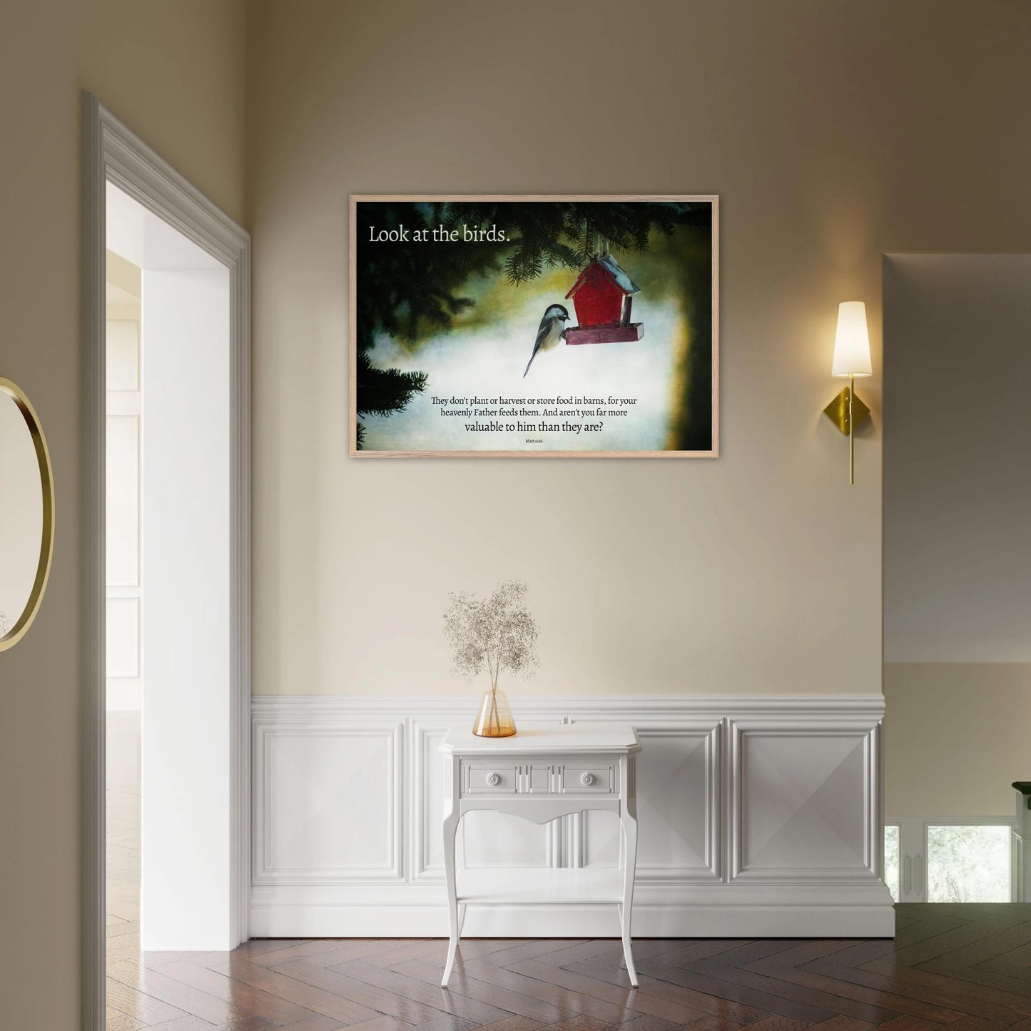 Framed artwork of birds and a red birdhouse on a wall above a white console table.