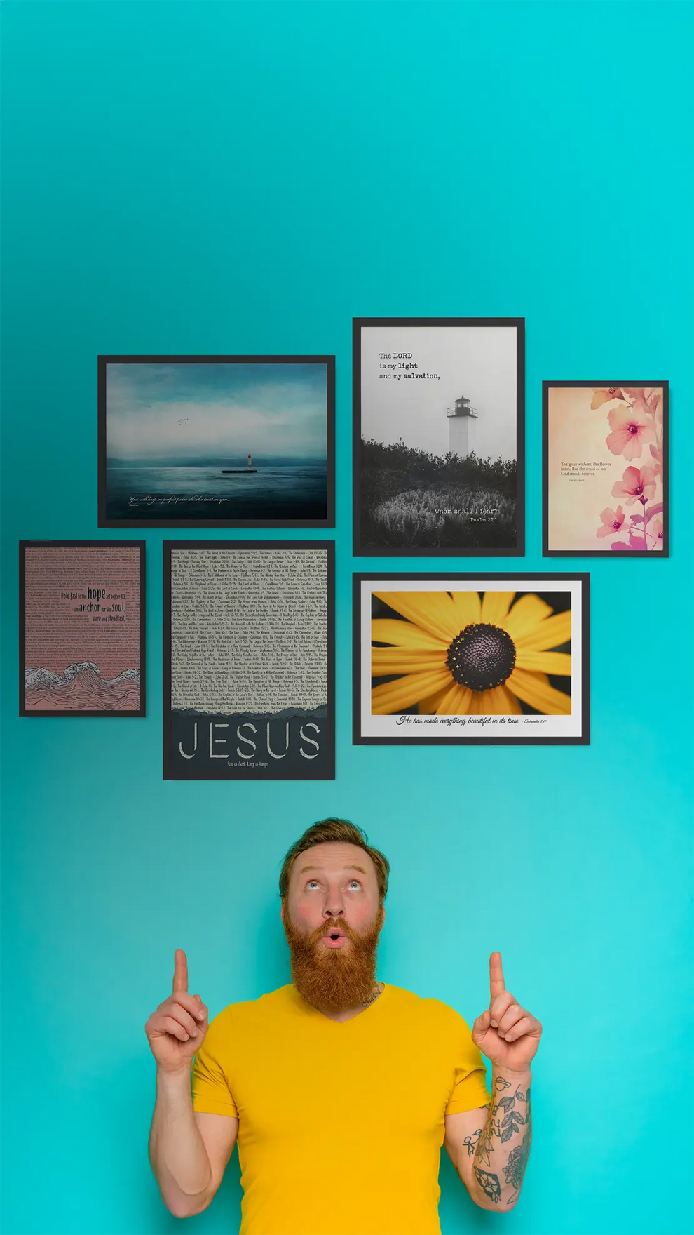 Man in a yellow shirt pointing at framed pictures on a blue wall with 'Jesus' in a frame.