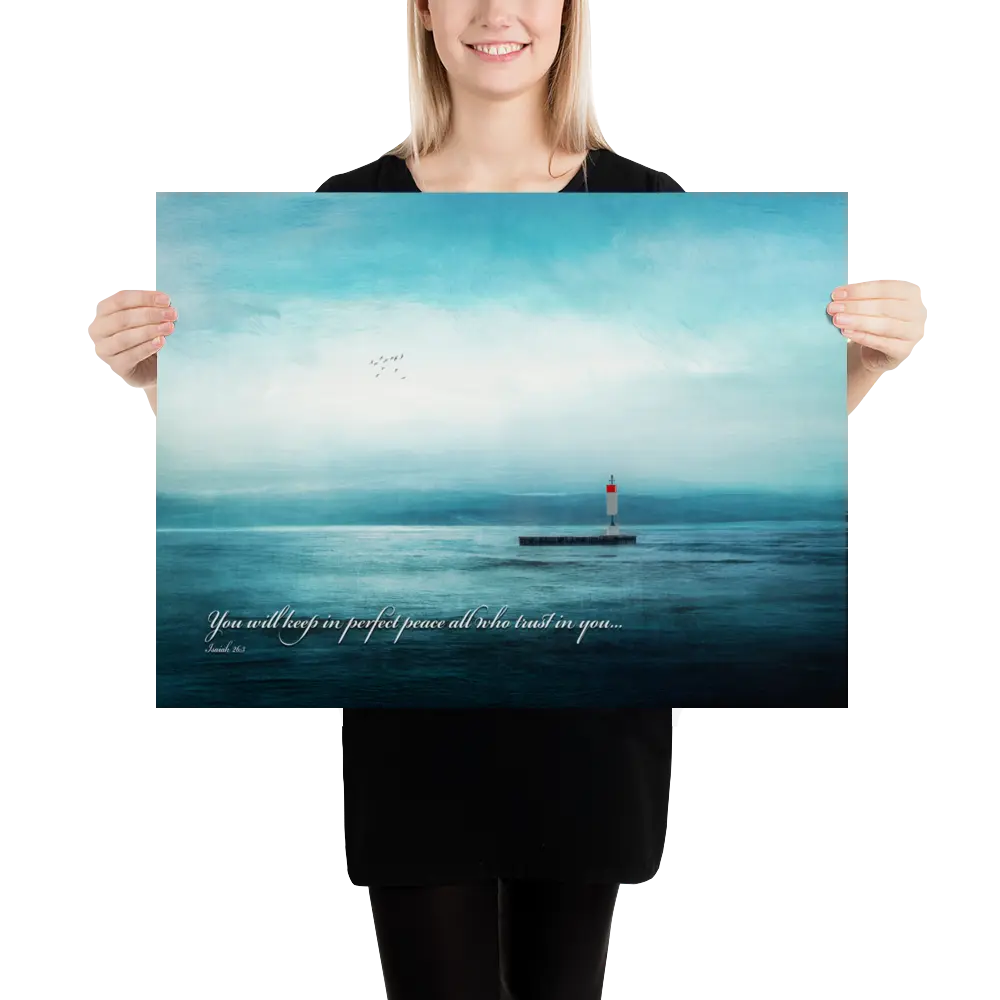 Person holding a poster with a lighthouse on an ocean scene and a quote.