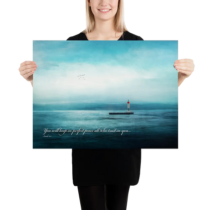 Person holding a poster with a lighthouse on an ocean scene and a quote.