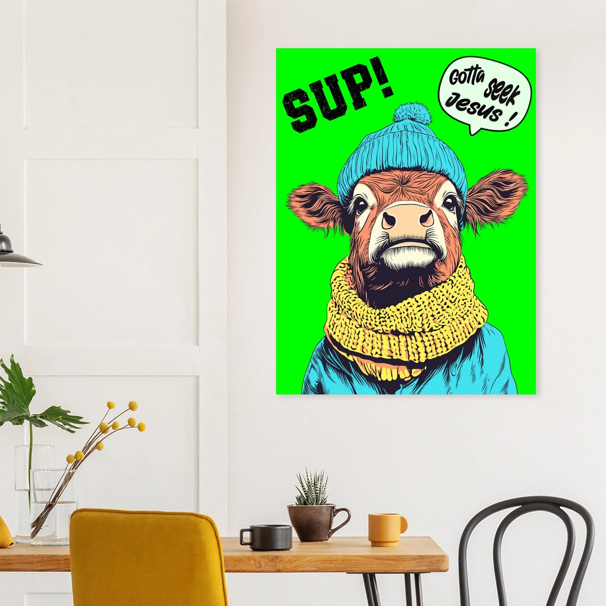 Poster of a cow wearing a blue beanie and yellow scarf with text on a green background, hanging above a table.