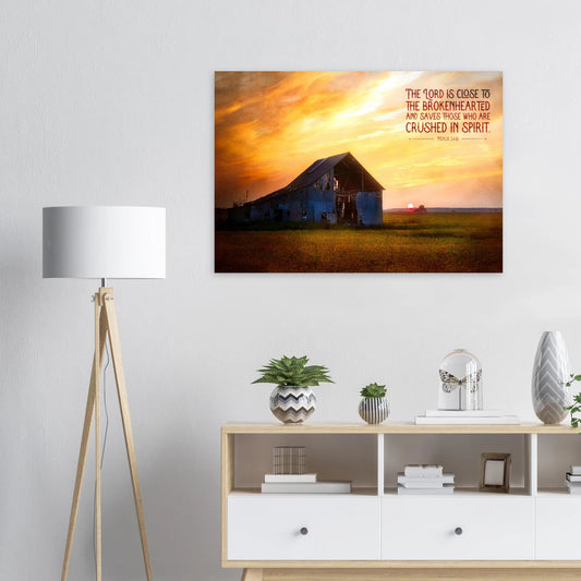 Framed artwork of a sunset over a barn with a motivational quote on a wall above a white cabinet.