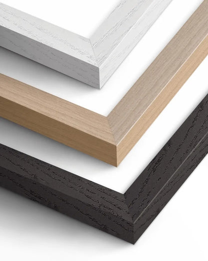Close-up of three wooden picture frame corners in white, natural, and black finishes.