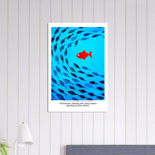 Christian wall art showing a red fish swimming against a school of blue fish with the message Sometimes standing with Jesus means standing out displayed in a bright minimalist room