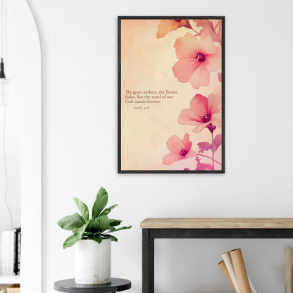 Framed Christian wall art with pink flowers and Isaiah 40:8 displayed above a plant on a side table in a bright modern living room.
