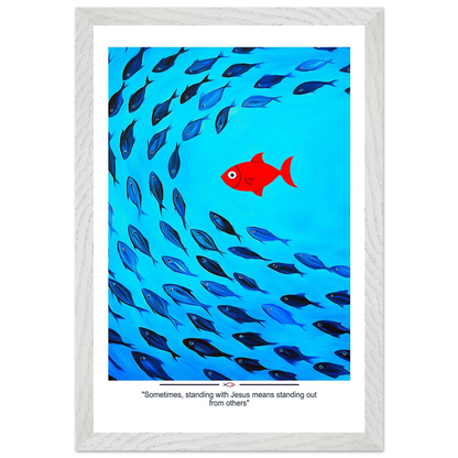 Framed Christian wall art featuring a red fish swimming in water with blue fish, and the text 'Sometimes standing with Jesus means standing out from others' as a quote.