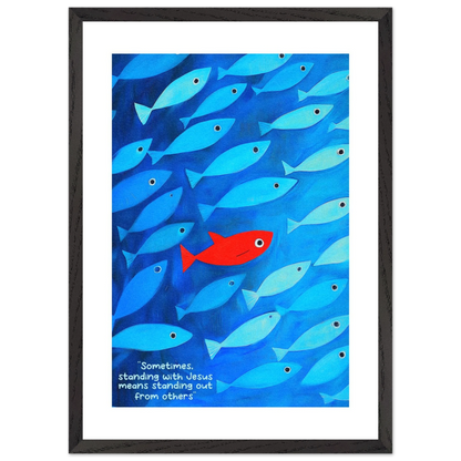 Framed wall art featuring a school of blue fish with a single red fish, and text that reads: 'Sometimes standing with Jesus means standing out from others.'.