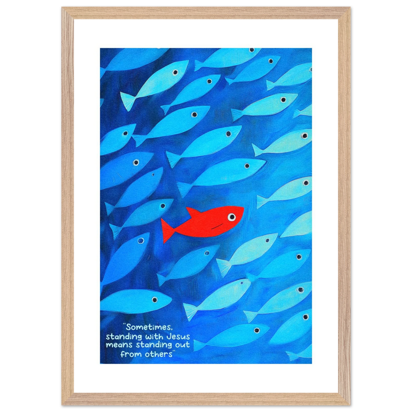 Framed wall art featuring a school of blue fish with a single red fish, and text that reads: 'Sometimes standing with Jesus means standing out from others.'.