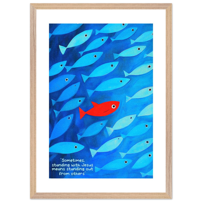 Framed wall art featuring a school of blue fish with a single red fish, and text that reads: 'Sometimes standing with Jesus means standing out from others.'.