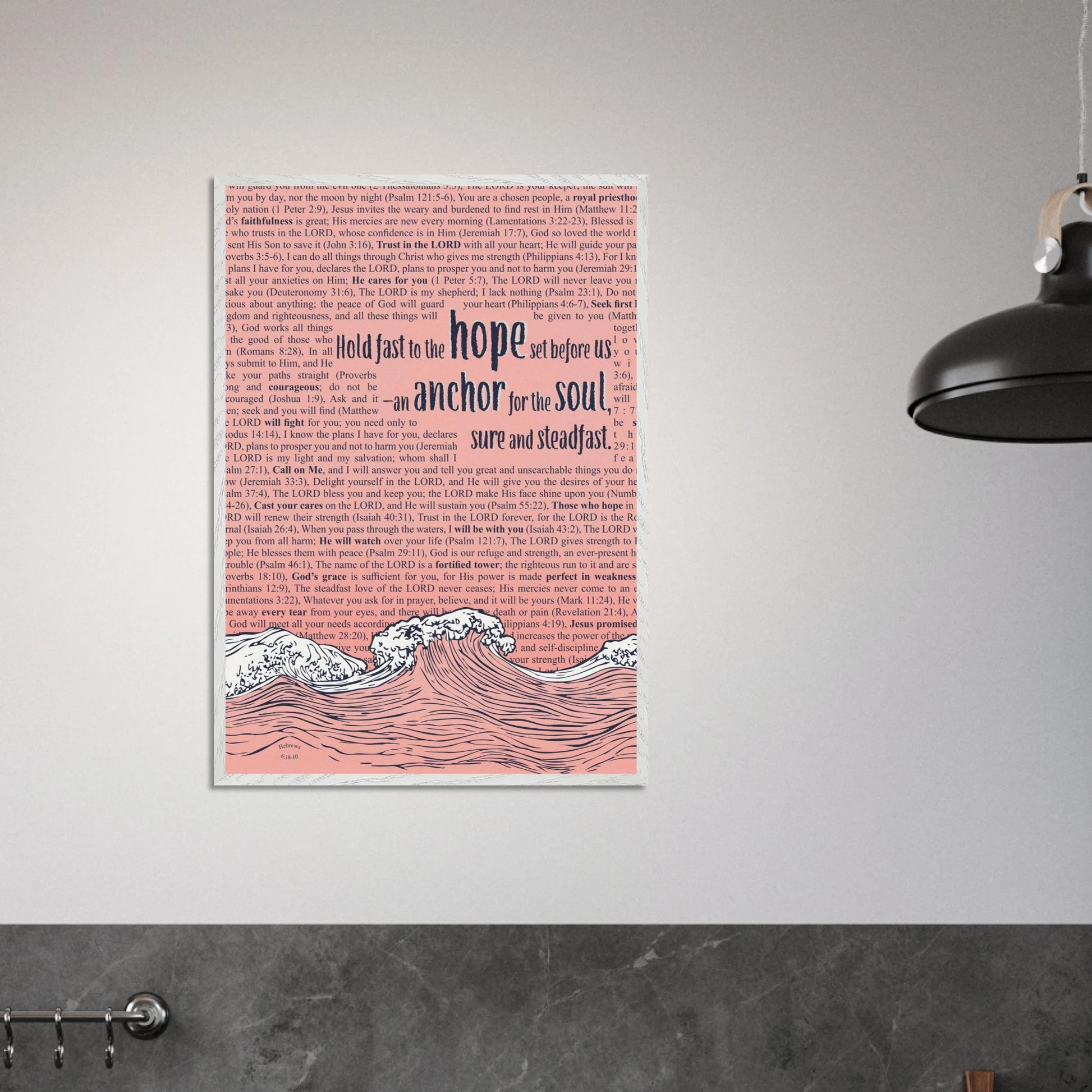 framed pink christian artwork with wave and anchor design and bible verse displayed on a modern grey wall