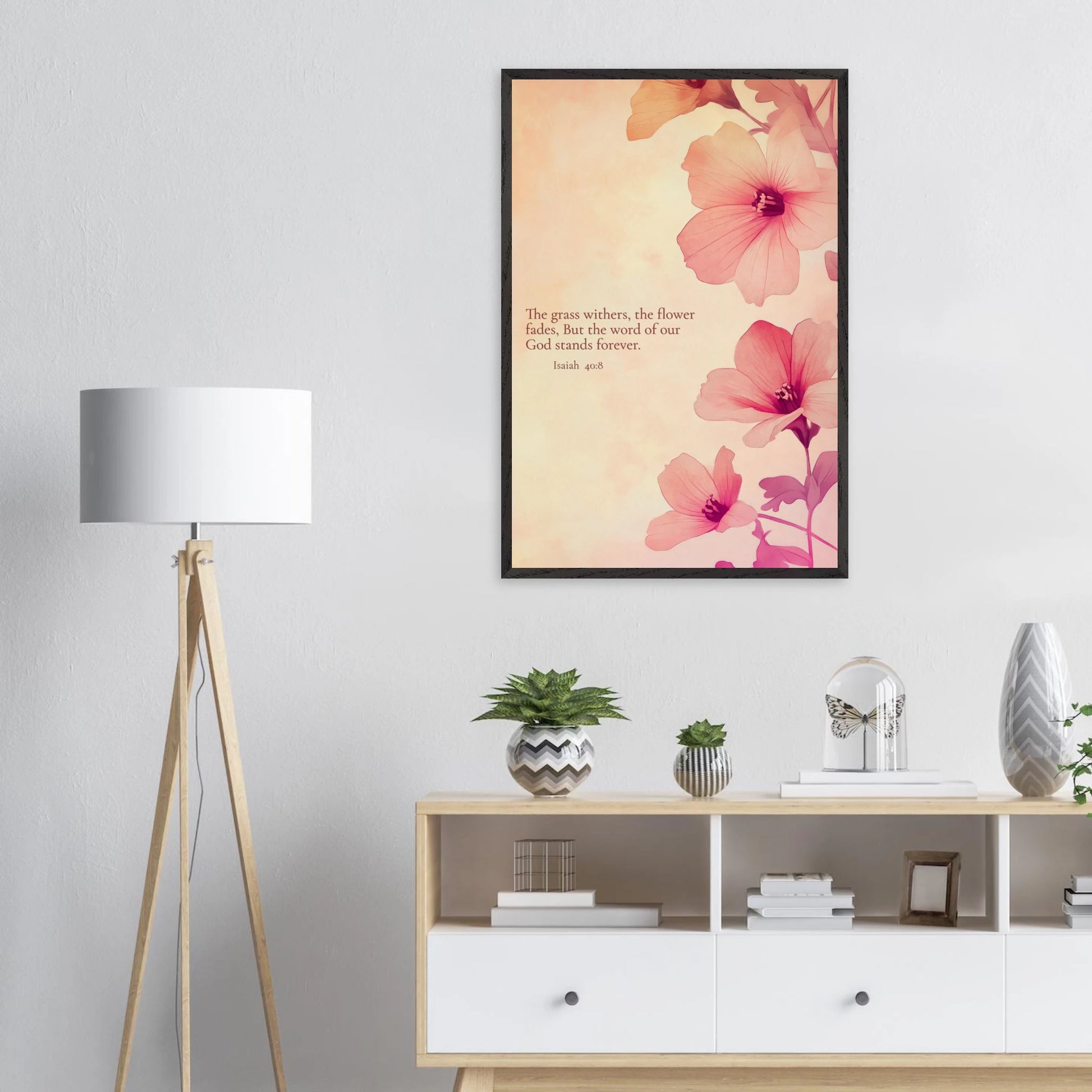 Large framed floral wall art with Isaiah 40:8 displayed above a white cabinet and floor lamp in a minimalist living room.