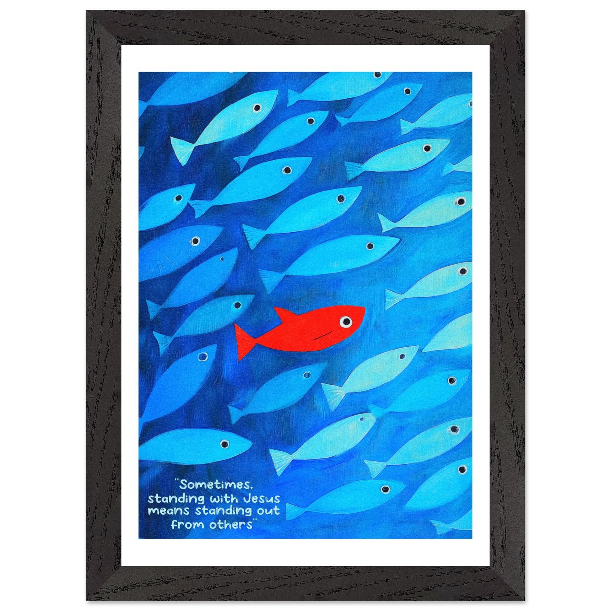 Framed wall art featuring a school of blue fish with a single red fish, and text that reads: 'Sometimes standing with Jesus means standing out from others.'.