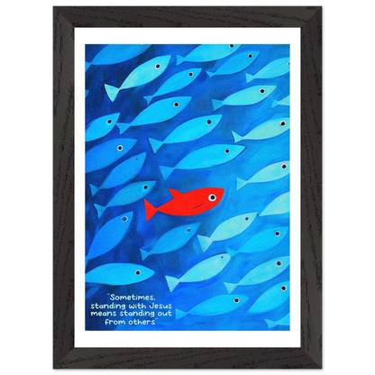 Framed wall art featuring a school of blue fish with a single red fish, and text that reads: 'Sometimes standing with Jesus means standing out from others.'.