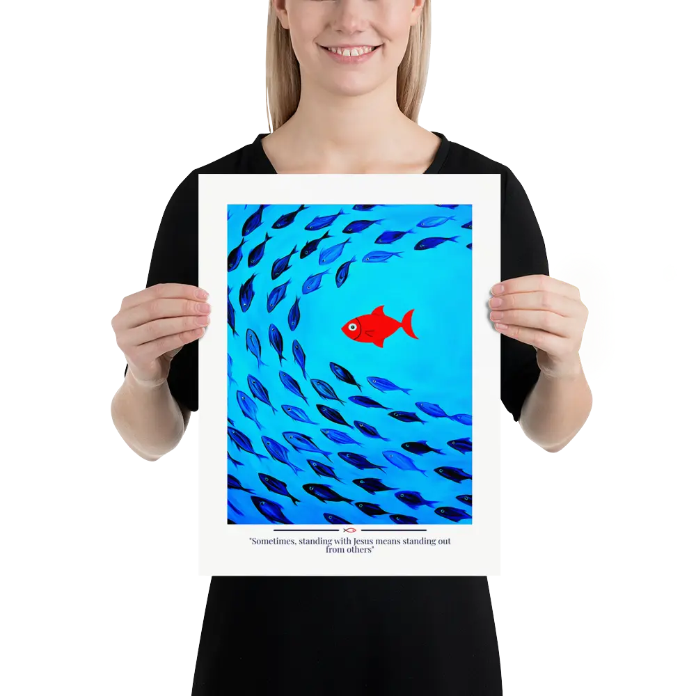 Person holding a framed artwork with blue fish and a red fish on a white background