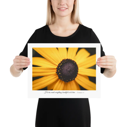 Person holding a framed print of a yellow flower with a black center.