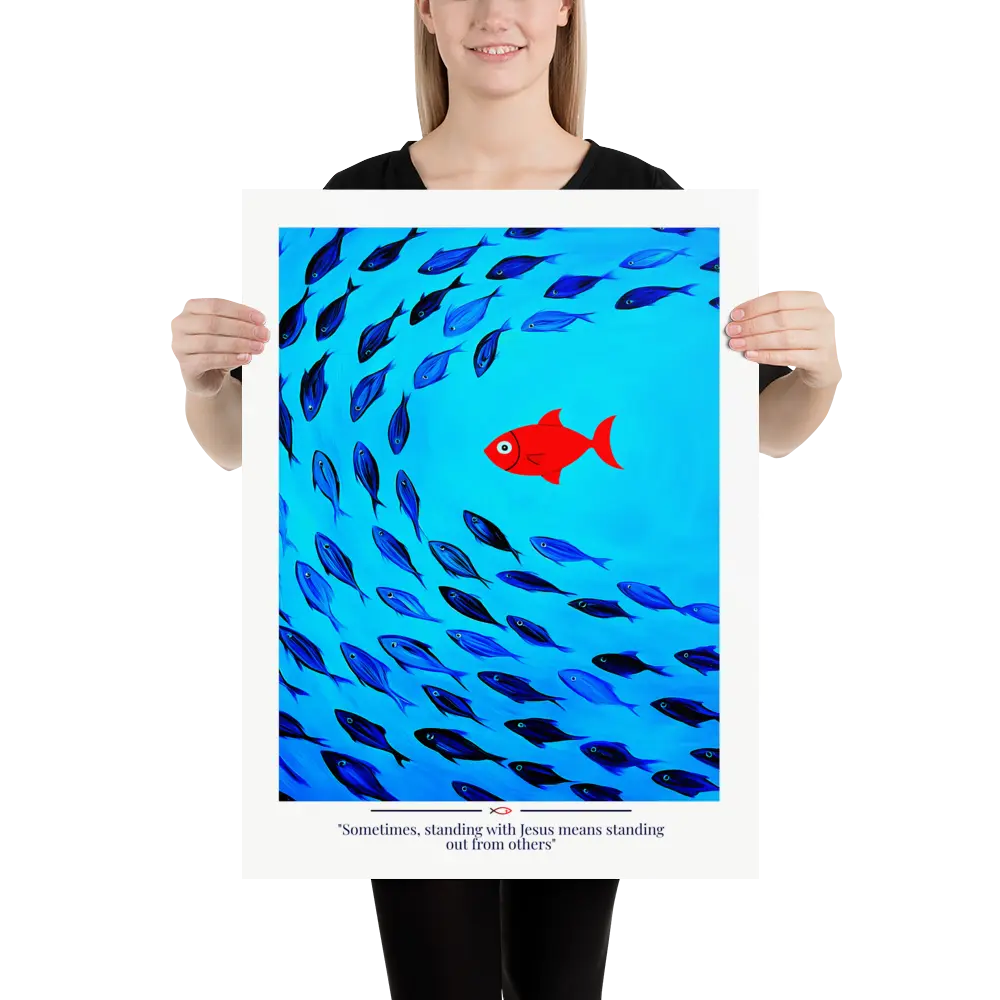 Person holding a poster with a red fish among blue fish and text on a white background