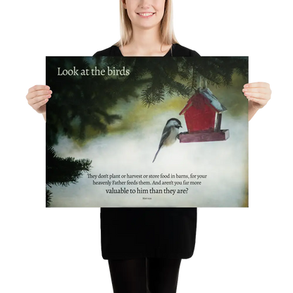 Person holding a poster with a bird and birdhouse illustration and text.