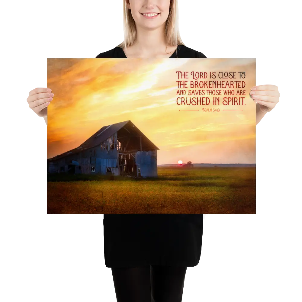 Person holding a poster with a barn and sunset scene and inspirational text.