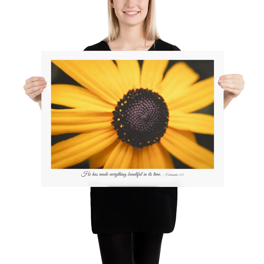 Person holding a large print of a yellow flower with a black center.